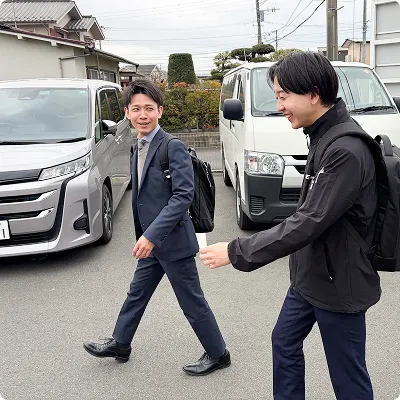 社員と顧客が話しながら一緒に歩いている画像